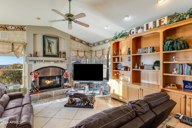 tiled living room featuring ceiling fan, a fireplace, and lofted ceiling