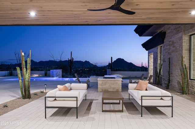 28805 N 114th St, Scottsdale, AZ 85262 - patio terrace at dusk featuring an outdoor living space, ceiling fan, a mountain view, and an outdoor pool