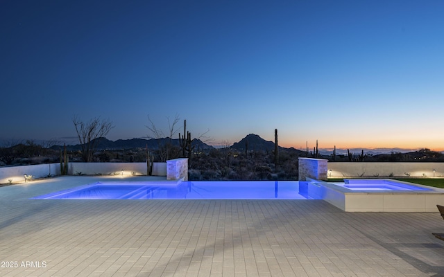 28805 N 114th St, Scottsdale, AZ 85262 - pool at dusk featuring a pool with connected hot tub, a patio area, and a mountain view
