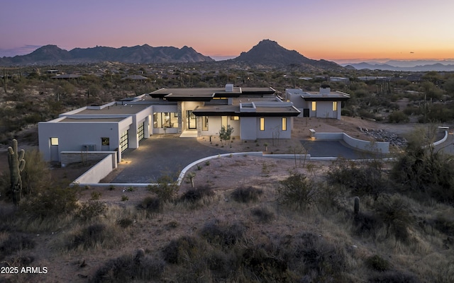 28805 N 114th St, Scottsdale, AZ 85262 - back of house at dusk featuring driveway, stucco siding, an attached garage, and a mountain view