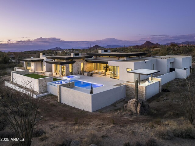 patio terrace at dusk featuring a mountain view and an outdoor fire pit