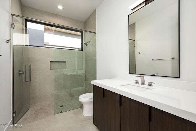 bathroom featuring tile patterned flooring, vanity, an enclosed shower, and toilet