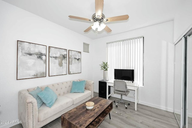 living room with light hardwood / wood-style floors and ceiling fan