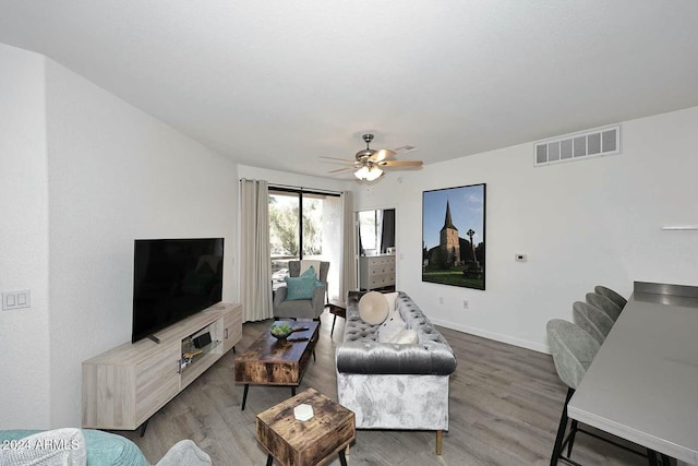 living room featuring hardwood / wood-style floors and ceiling fan