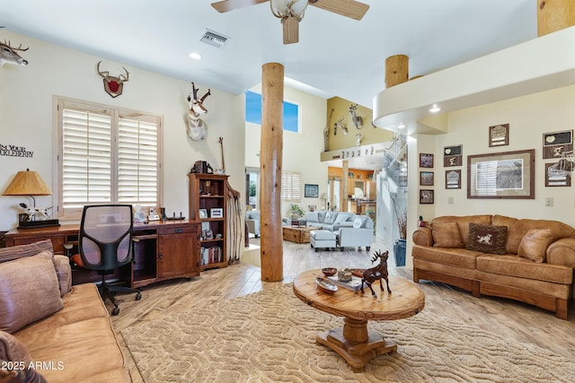 living room with ceiling fan and light hardwood / wood-style flooring