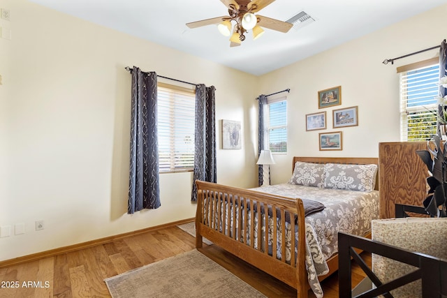 bedroom with multiple windows, ceiling fan, and hardwood / wood-style flooring