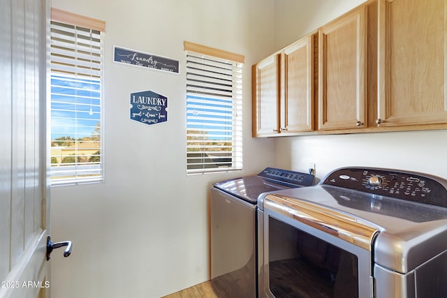 laundry area with cabinets, independent washer and dryer, and plenty of natural light