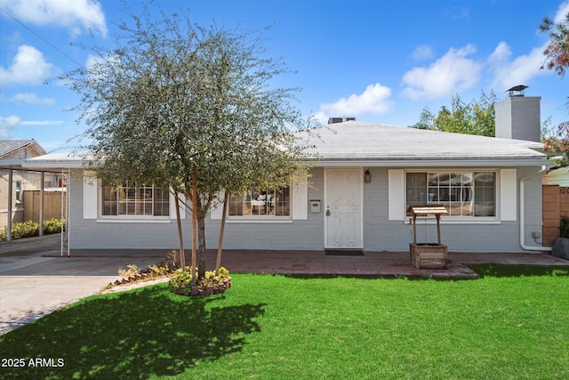 view of front of property with a front lawn, fence, brick siding, and driveway