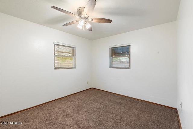 spare room with ceiling fan, baseboards, and carpet