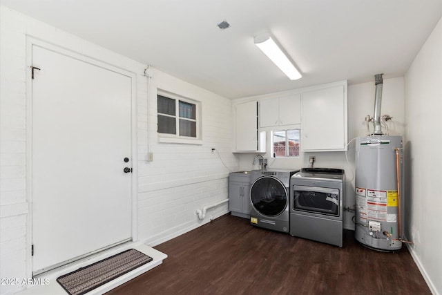 laundry area with a sink, dark wood finished floors, water heater, cabinet space, and washing machine and clothes dryer