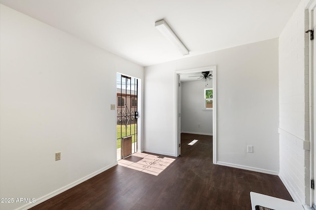 unfurnished room with ceiling fan, baseboards, and wood finished floors