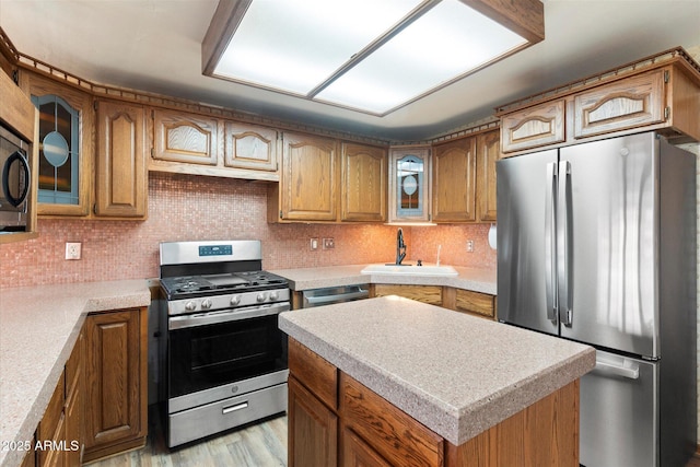 kitchen with a sink, stainless steel appliances, and brown cabinetry