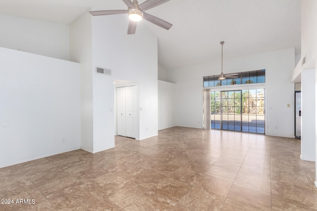 empty room with high vaulted ceiling and ceiling fan