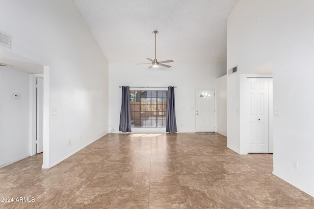 unfurnished living room with ceiling fan, a textured ceiling, and high vaulted ceiling