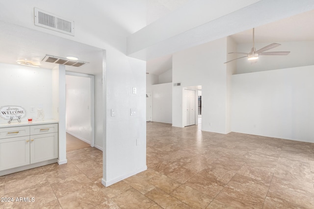 unfurnished room with ceiling fan and high vaulted ceiling