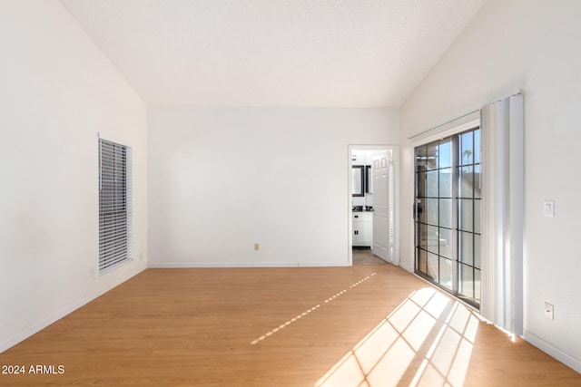 unfurnished room with lofted ceiling and wood-type flooring