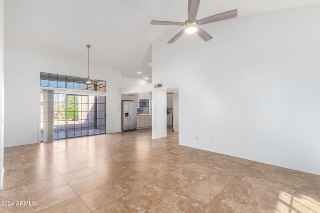 unfurnished living room featuring high vaulted ceiling and ceiling fan