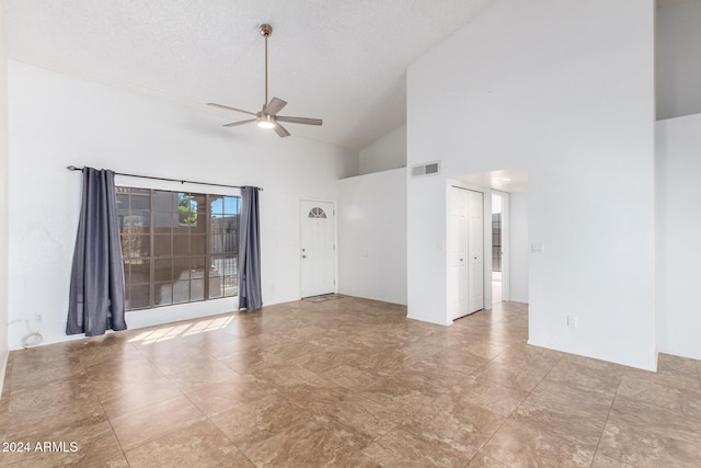 spare room with ceiling fan, a textured ceiling, and high vaulted ceiling