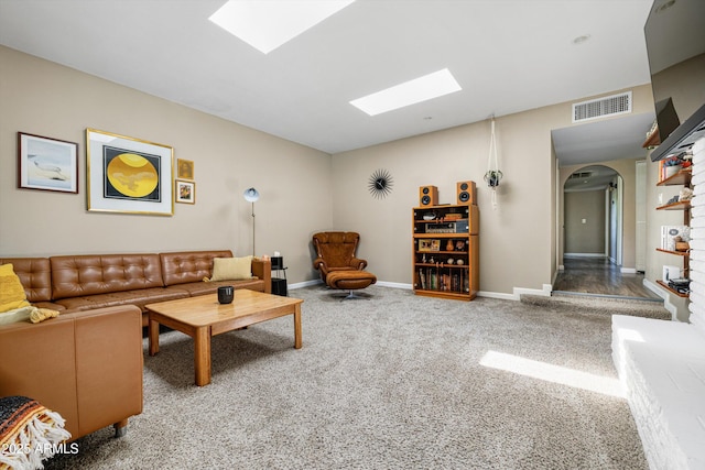 8502 E Rose Ln, Scottsdale, AZ 85250 - carpeted living room with a skylight, arched walkways, and baseboards