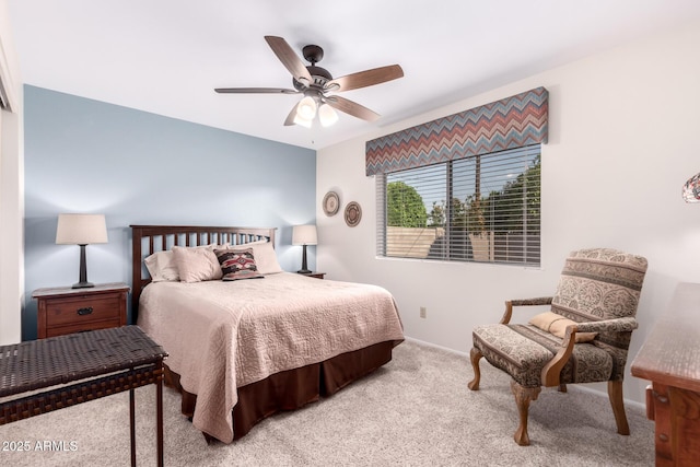 bedroom featuring light colored carpet, a ceiling fan, and baseboards