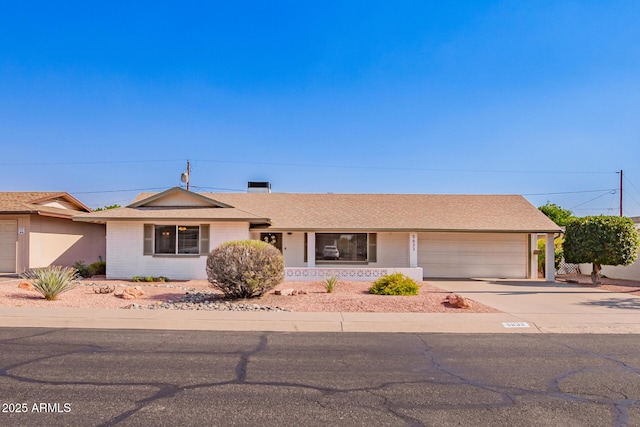ranch-style house with a garage, concrete driveway, brick siding, covered porch, and roof with shingles