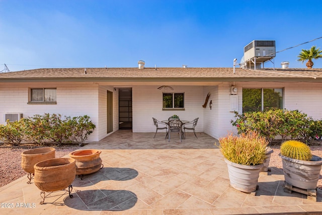 back of house featuring central air condition unit, a patio area, and brick siding