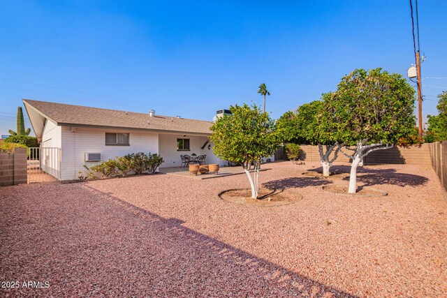 rear view of house featuring a fenced backyard and a patio