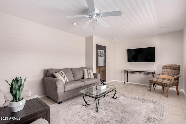 living room featuring light tile patterned floors, ceiling fan, and baseboards