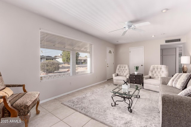 living room featuring tile patterned flooring, a ceiling fan, and baseboards
