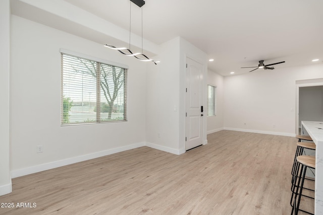 unfurnished dining area with light hardwood / wood-style flooring and ceiling fan