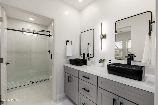 bathroom featuring vanity, toilet, and a shower with shower door