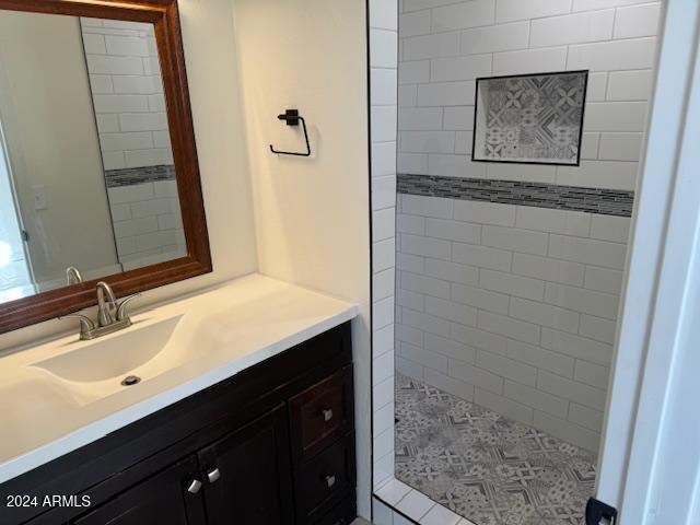 bathroom with vanity and a tile shower