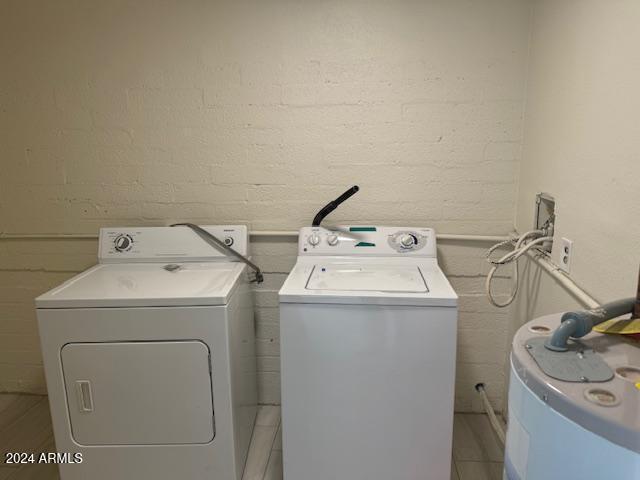 clothes washing area with electric water heater and independent washer and dryer