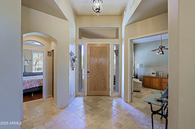 32516 N 68th Pl, Scottsdale, AZ 85266 - foyer with stone tile flooring, arched walkways, crown molding, ceiling fan, and baseboards