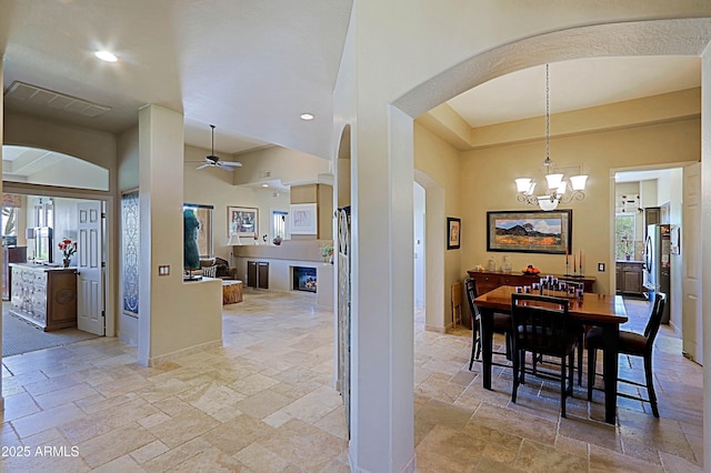 32516 N 68th Pl, Scottsdale, AZ 85266 - dining room featuring stone tile floors, arched walkways, a chandelier, ceiling fan, and recessed lighting