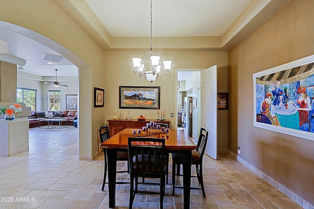 32516 N 68th Pl, Scottsdale, AZ 85266 - dining area with stone tile flooring, arched walkways, a chandelier, ceiling fan, and a tray ceiling