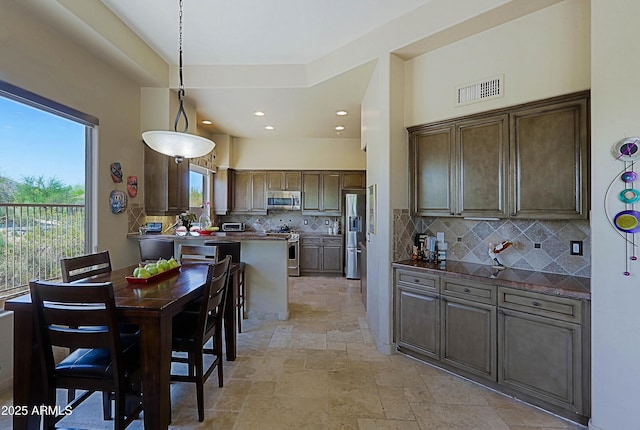 32516 N 68th Pl, Scottsdale, AZ 85266 - kitchen with appliances with stainless steel finishes, stone tile flooring, tasteful backsplash, dark countertops, and recessed lighting