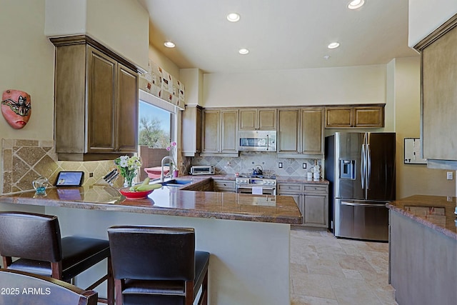 32516 N 68th Pl, Scottsdale, AZ 85266 - kitchen with stainless steel appliances, a sink, a peninsula, decorative backsplash, and recessed lighting