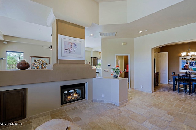 32516 N 68th Pl, Scottsdale, AZ 85266 - kitchen featuring a chandelier, arched walkways, ceiling fan, stone tile flooring, and a high ceiling
