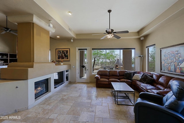 32516 N 68th Pl, Scottsdale, AZ 85266 - living area with ceiling fan, a glass covered fireplace, stone tile flooring, and recessed lighting