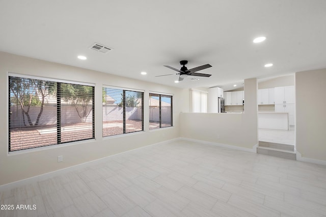 tiled spare room featuring ceiling fan