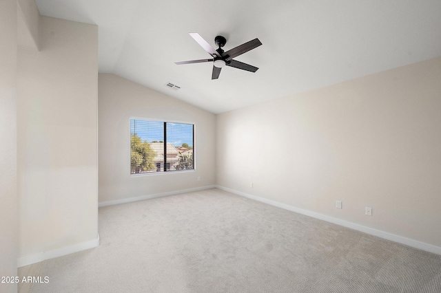 spare room featuring ceiling fan, light colored carpet, and vaulted ceiling