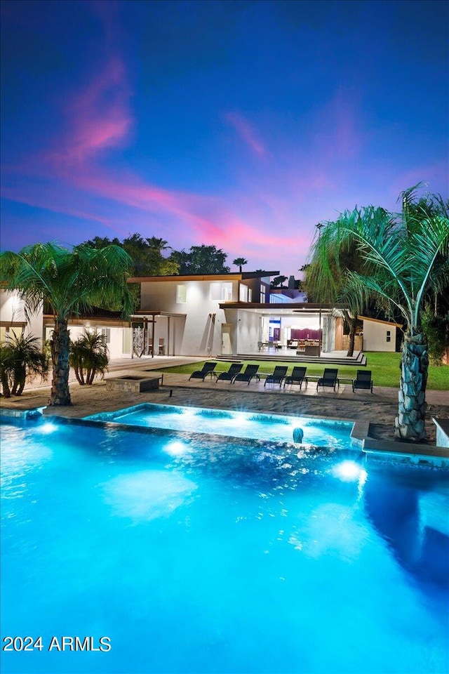 pool at dusk featuring a patio area