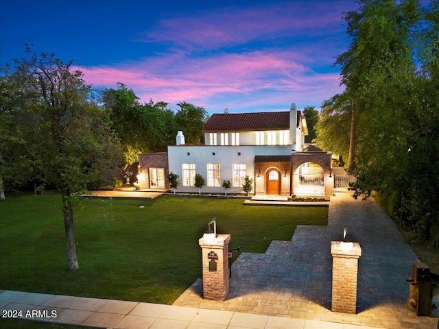 mediterranean / spanish-style house with a lawn and a patio