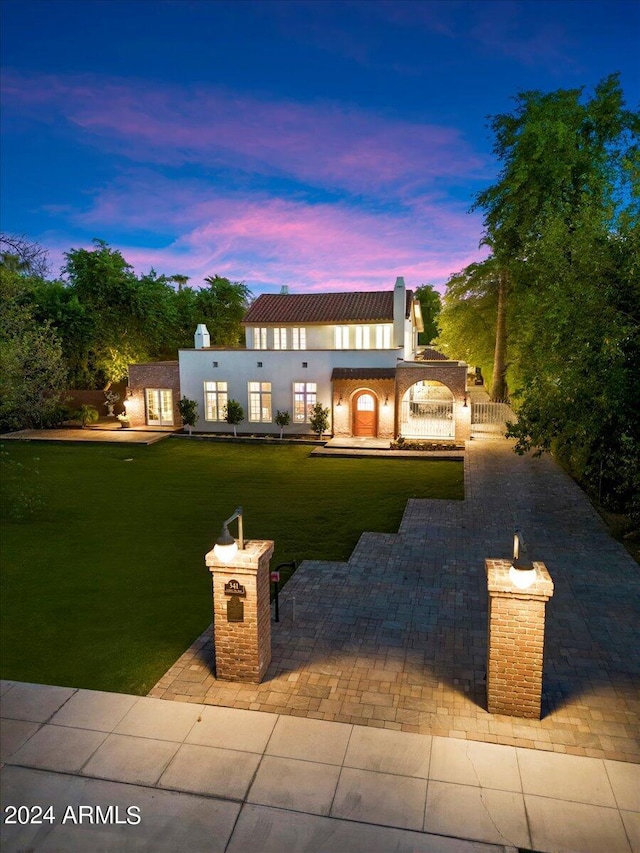 view of front facade with a lawn and a patio area