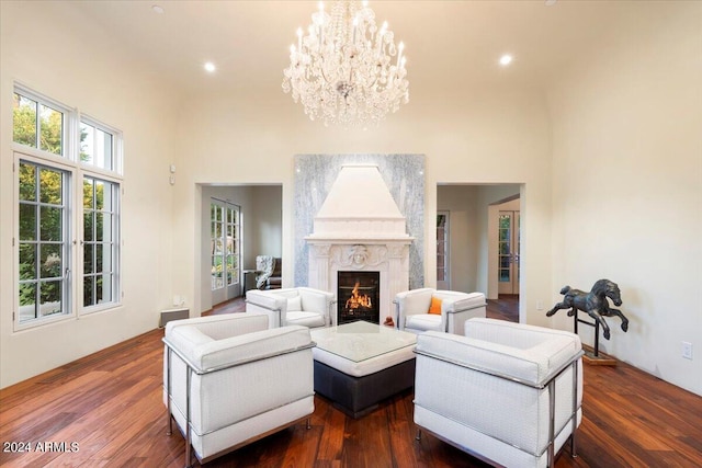 living room with a premium fireplace, dark hardwood / wood-style flooring, and a high ceiling