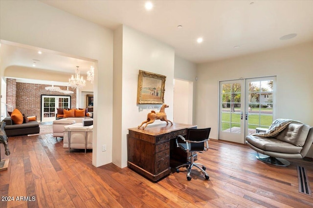 office space featuring an inviting chandelier, hardwood / wood-style floors, and french doors