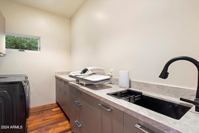 kitchen featuring washer and clothes dryer, lofted ceiling, sink, and dark hardwood / wood-style flooring