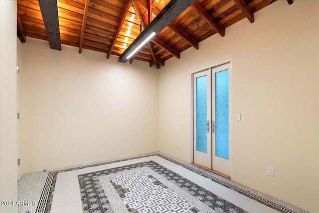 empty room featuring french doors, lofted ceiling with beams, and wooden ceiling