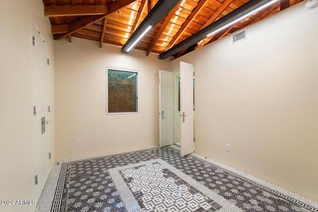 empty room featuring lofted ceiling with beams and wooden ceiling